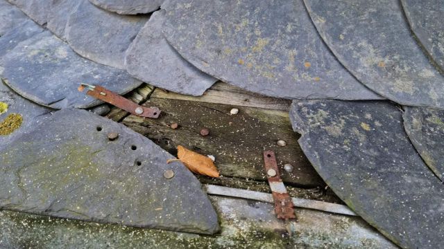 fehlende Schieferplatte und verwittertes Holzbrett