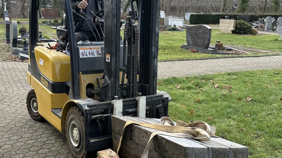 Der Gedenkstein wird zur Restaurierung in die Friedhodshalle gefahren